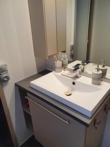 a bathroom with a sink and a mirror at Mobil-Home camping 4**** LA MARINE in Le Grau-du-Roi