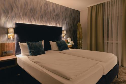 a bedroom with a large bed with a large headboard at Hotel & Restaurant Rose in Bietigheim-Bissingen