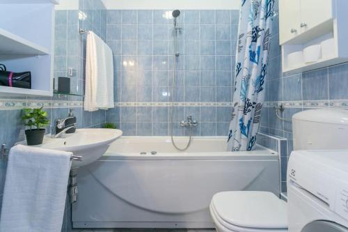 een badkamer met een bad, een wastafel en een toilet bij Swanky Gem in Dubrovnik