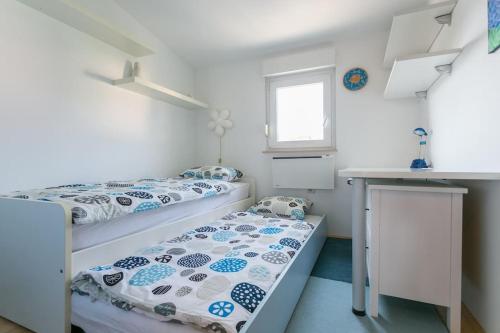 een slaapkamer met twee bedden, een bureau en een raam bij Swanky Gem in Dubrovnik