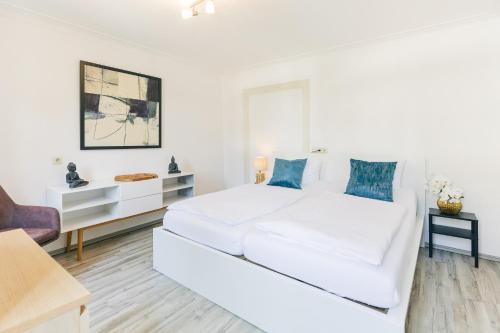 a white living room with a white couch at Hotel & Restaurant Rose in Bietigheim-Bissingen
