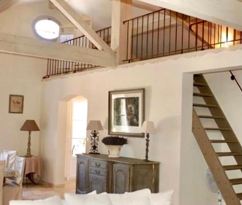 un salon avec un escalier et un canapé dans l'établissement Élégance et simplicité au cœur des vignes, à Visan