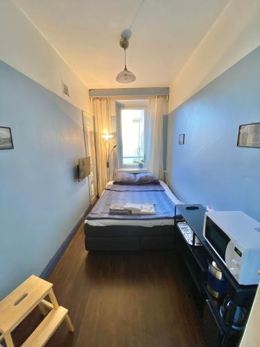 Yksityinen huone ja kylpyhuone kaupungin keskustassa في هلسنكي: غرفة صغيرة بها سرير ونافذة