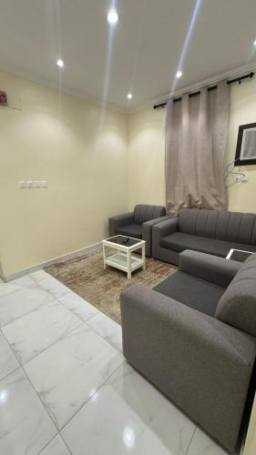 a living room with two couches and a table at دانه القحطاني للوحدات السكنية in Tabuk