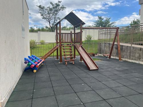 a playground with a slide and a swing set at Apartamento aconchegante em Betim in Betim