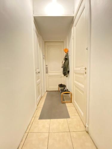 a hallway with a door and a tile floor at Yksityinen huone ja kylpyhuone kaupungin keskustassa in Helsinki