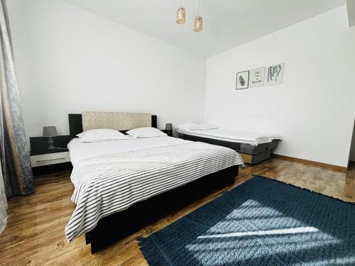 um quarto com uma cama e um tapete azul em DAS home-Apartament cu vedere la munte em Rasnov