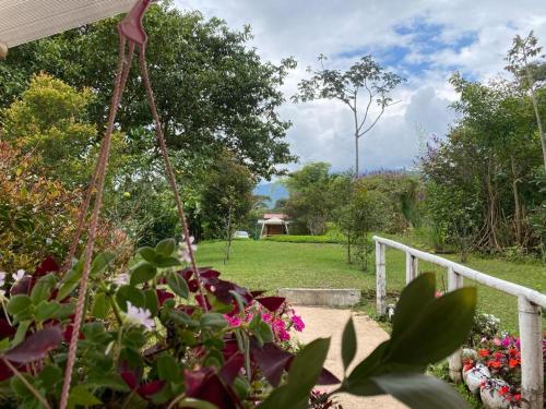 a garden with flowers and a white fence at Green Bamboo Lodge in San Francisco de Borja