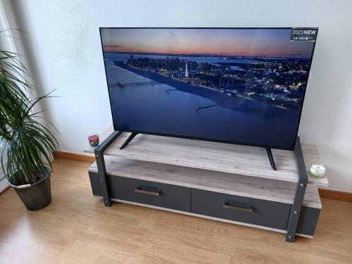 einen großen Flachbild-TV auf einem Stand in einem Zimmer in der Unterkunft Suite Kursaal met zeezicht in Ostende