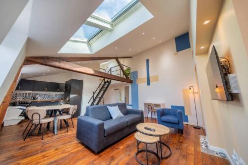 Una sala de estar con un sofá azul y una mesa. en Le Joyau, en Reims