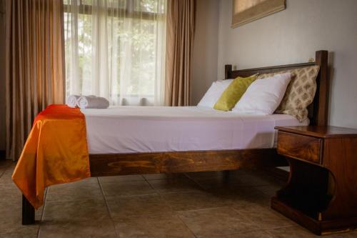 a bedroom with a large bed with a window at Miradas Arenal Hotel & Hotsprings in Fortuna