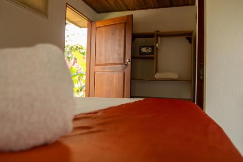 a bedroom with a bed and a open door at Miradas Arenal Hotel & Hotsprings in Fortuna