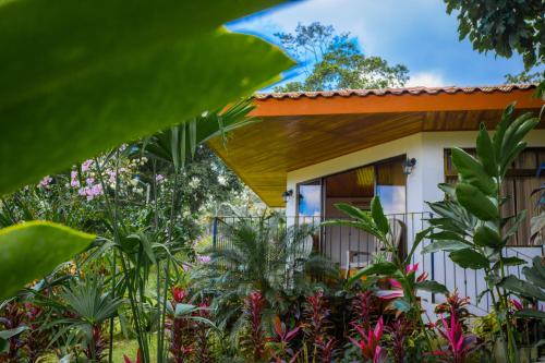 a house in the middle of a garden at Miradas Arenal Hotel & Hotsprings in Fortuna