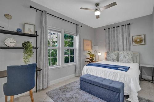 a bedroom with a bed and a chair and a window at Stunning 2/2 dream beach house in Surfside in Miami Beach