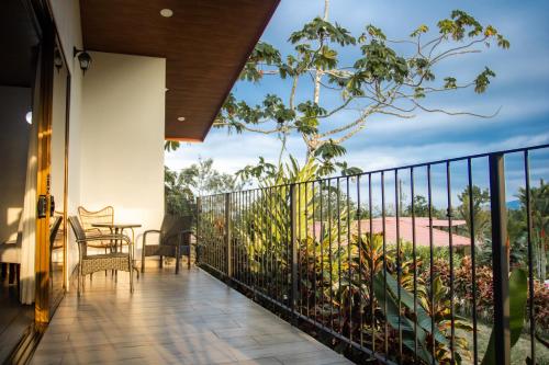 a balcony of a house with a table and chairs at Miradas Arenal Hotel & Hotsprings in Fortuna