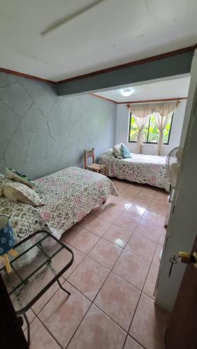 a room with two beds and a window at Hostal Vieroto in Hanga Roa