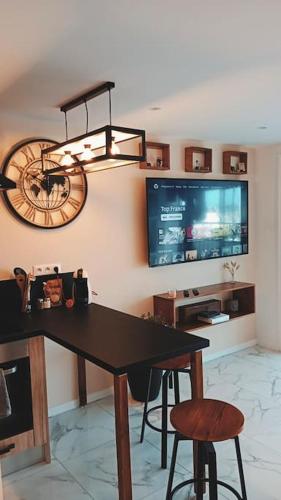 Cette chambre comprend une table, une télévision et un lustre. dans l'établissement Appartement 2 personnes, à Canet