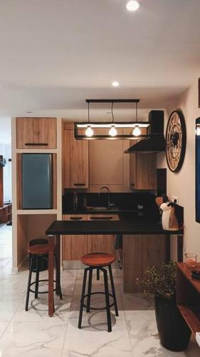 une cuisine avec un comptoir noir et deux tabourets dans l'établissement Appartement 2 personnes, à Canet