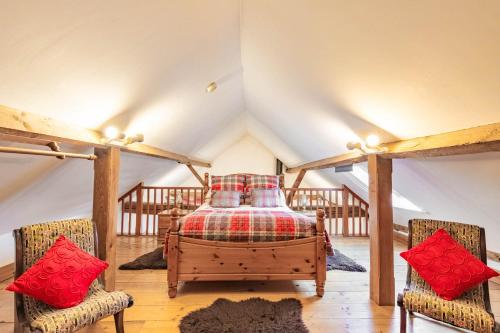 a bedroom with a bed in a attic at Threshers Barn and Shire Horse Barn in Cawston