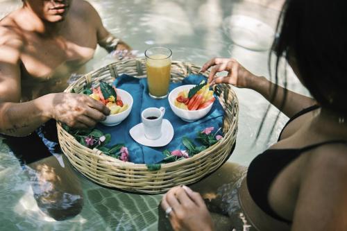 a group of people eating food in the water at Villas Zamna - Jungle Villas in Cozumel