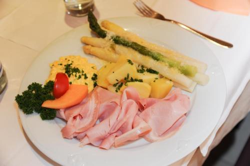 a plate of food with meat and vegetables on a table at Gasthof Stern in Prato allo Stelvio