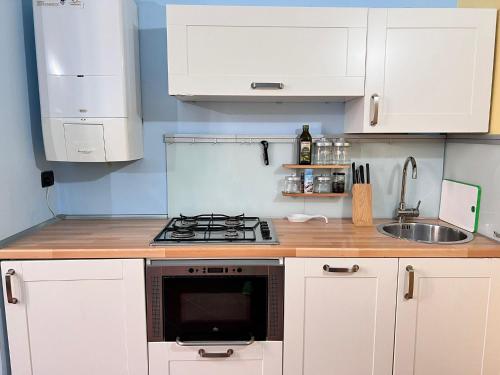 a kitchen with white cabinets and a stove top oven at CASA ELENA in Sanremo