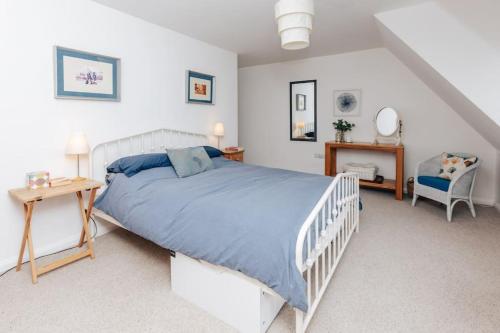 a white bedroom with a bed and a chair at TheTulips- 4 bed, Henley Regatta in Henley on Thames