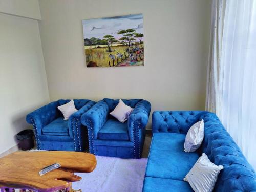 a living room with two blue couches and a table at Mupa's Luxury Condo I in Nyahururu