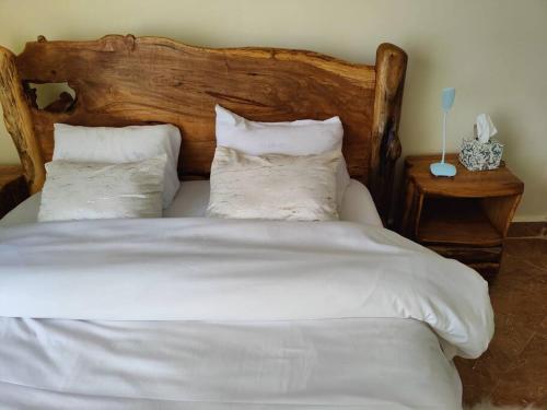 a bedroom with a large white bed with pillows at Mupa's Luxury Condo I in Nyahururu
