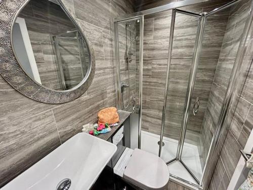 a bathroom with a shower and a sink and a mirror at Unique & Pet Friendly Luxury Retreat With Hot Tub in Horsham Saint Faith