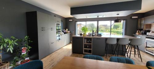 a kitchen with white cabinets and a table and chairs at Villa Oriel 1 à NEUFCHATEL-HARDELOT avec piscine privée in Neufchâtel-Hardelot