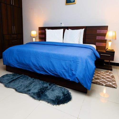 een slaapkamer met een blauw bed en een blauw dekbed bij MT Everest Hotel Ghana in Kwabenyan