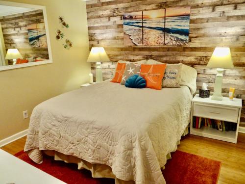 1 dormitorio con 1 cama y pared de madera en Gorgeous Ocean Views Patio Oasis Resort Amenities, en Myrtle Beach
