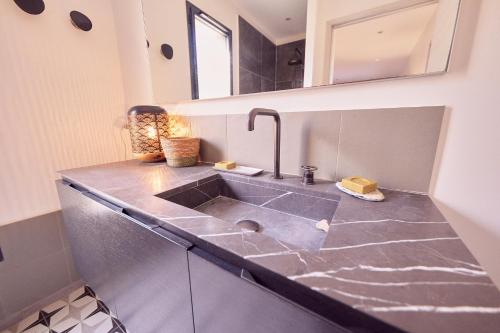 uma casa de banho com um lavatório e um espelho em Superbe villa avec piscine et vue mer + Revellata em Calvi