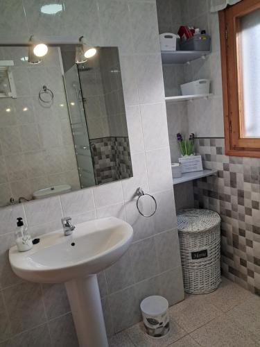 een badkamer met een wastafel en een spiegel bij CASA MARIA CINTA in Deltebre