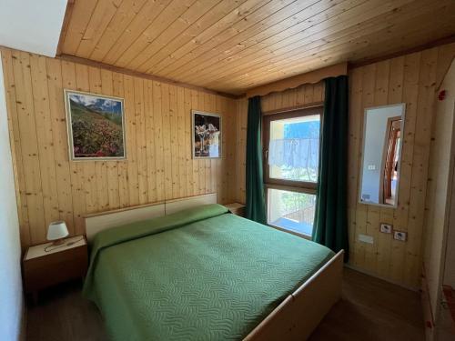 a bedroom with a green bed and a window at Casa vacanze Patty in Pracorno di Rabbi
