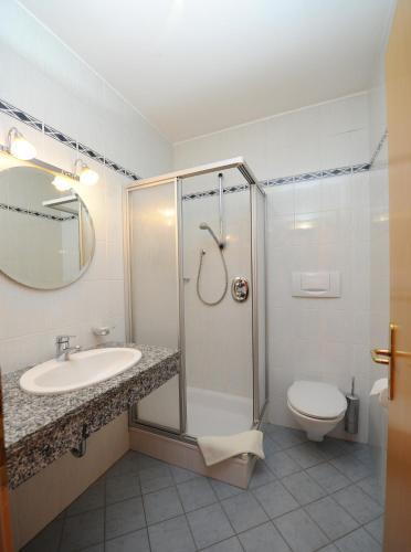 a bathroom with a shower and a sink and a toilet at Gasthof Stern in Prato allo Stelvio
