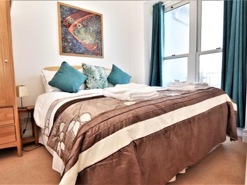 a bedroom with a large bed with blue pillows at 2 Bed in Ilfracombe CLOSE in Ilfracombe