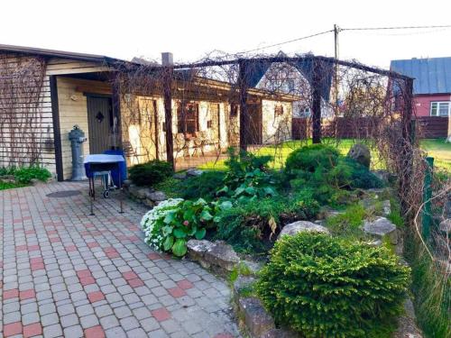 a garden in front of a house with a fence at Apartments Weintrauben in Pärnu