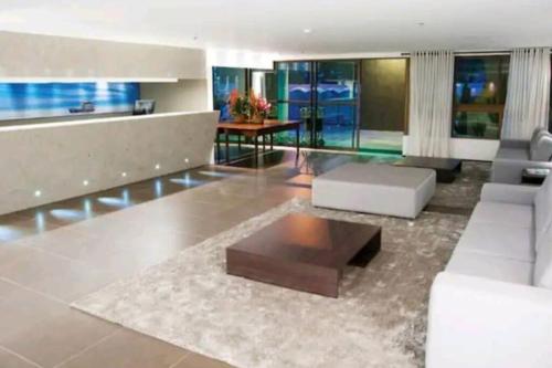 un salon avec un canapé blanc et une table basse dans l'établissement Lindo Apto beira-mar no Condomínio do Hotel Ritz Suítes Home Service, à Maceió