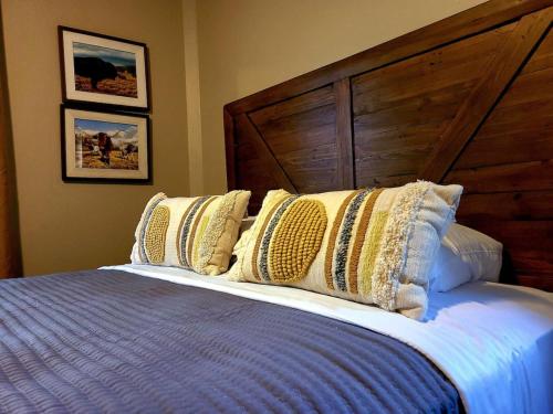 a bed with a wooden headboard and pillows on it at 4th Ave Hideaway - Cozy home with spacious yard in Columbia Falls