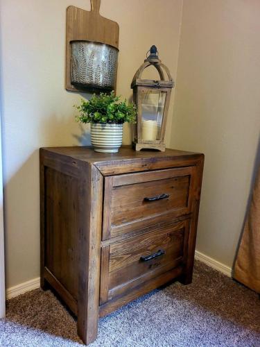 a wooden dresser with a plant on top of it at 4th Ave Hideaway - Cozy home with spacious yard in Columbia Falls