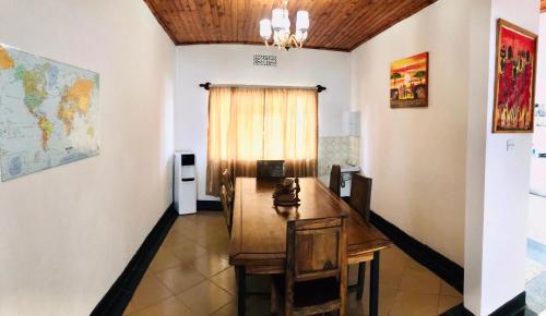 een eetkamer met een tafel en een kaart aan de muur bij COZY NYUMBA in Arusha