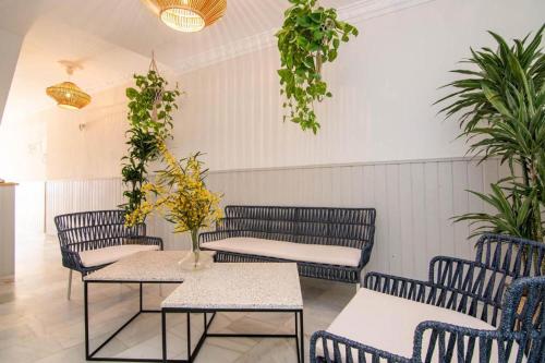 a room with tables and chairs and plants at Hostal El Alférez in El Palmar