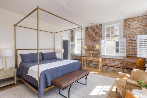 una camera con letto a baldacchino e muro di mattoni di State St B by AvantStay French Quarter Rooftop Aesthetic Design a Charleston