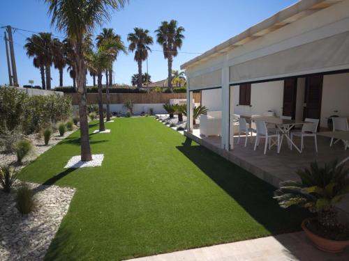 a garden with palm trees and a house at Villa Margherita in Marsala