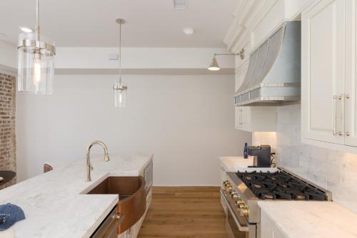 una cucina con lavandino e piano cottura di State St B by AvantStay French Quarter Rooftop Aesthetic Design a Charleston