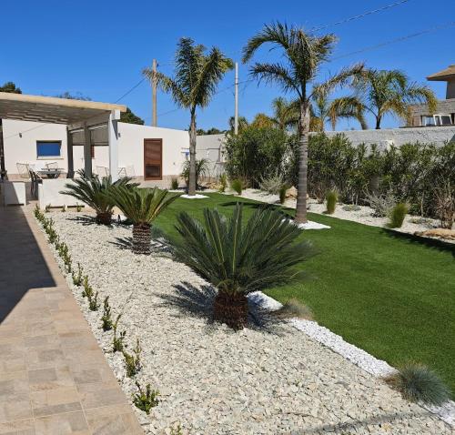 a garden with palm trees and a lawn at Villa Margherita in Marsala