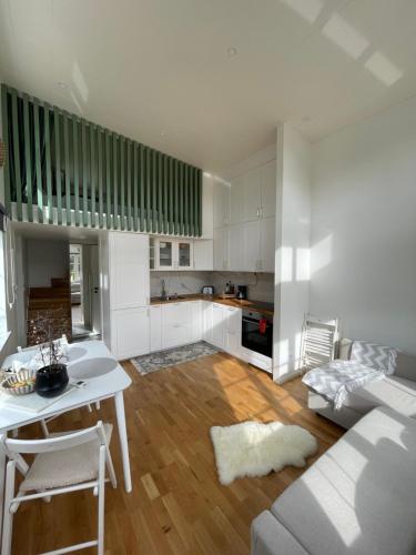 a kitchen and living room with a table and a couch at Ett nytt fräsch hus utanför Stockholm nära Arlanda in Rosersberg