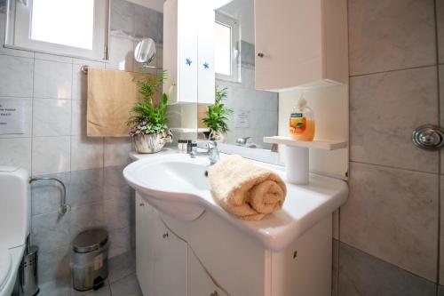 Baño blanco con lavabo y espejo en Rodini Sun Apartment en Rodas